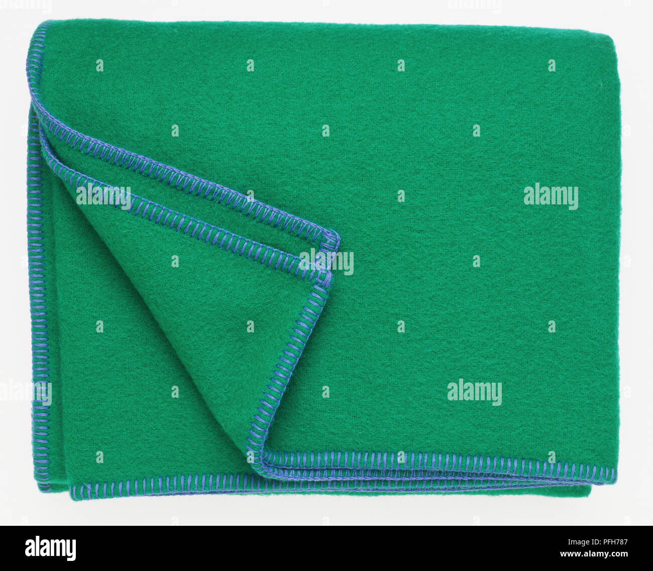 Green blanket with blue trim, folded over at the corner Stock Photo