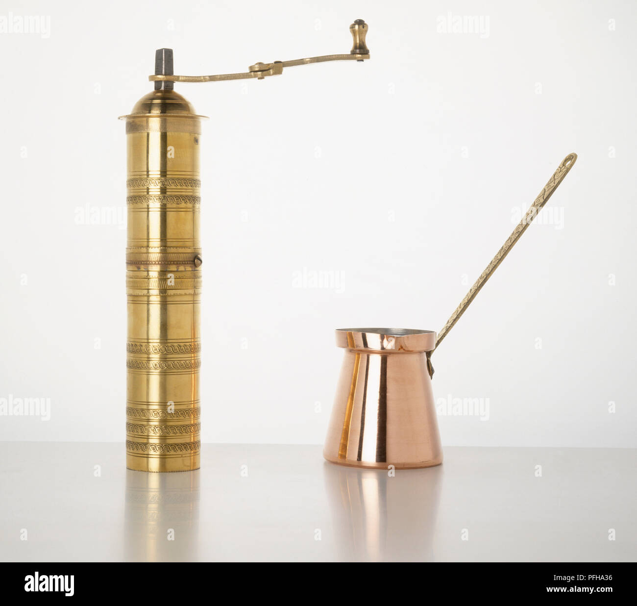Gold-coloured coffee grinder and coffee pot Stock Photo