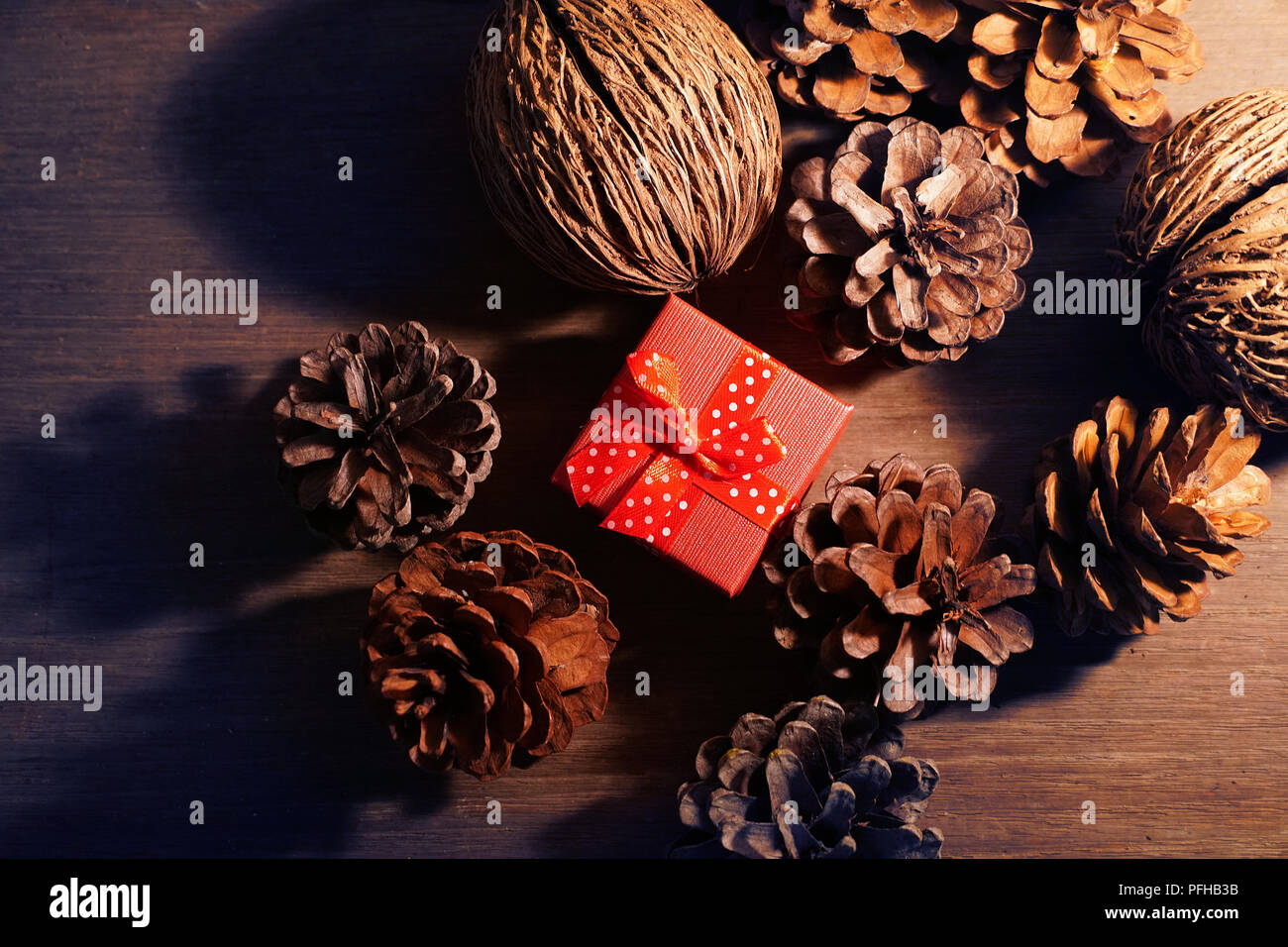 Topview red gift box on the center with group of pine cones. Stock Photo