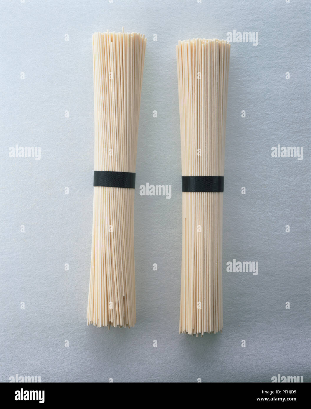 Two packets of rice noodles wrapped together with black bands. Stock Photo