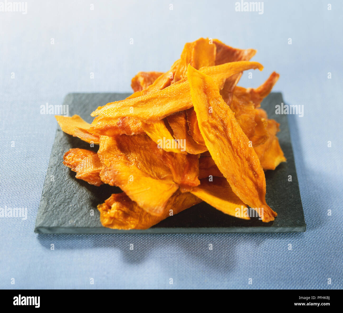 Slices of dried mango stacked in a pile, front view. Stock Photo