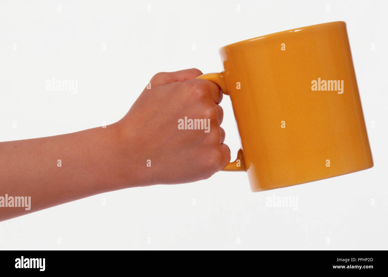 Person holding yellow mug Stock Photo