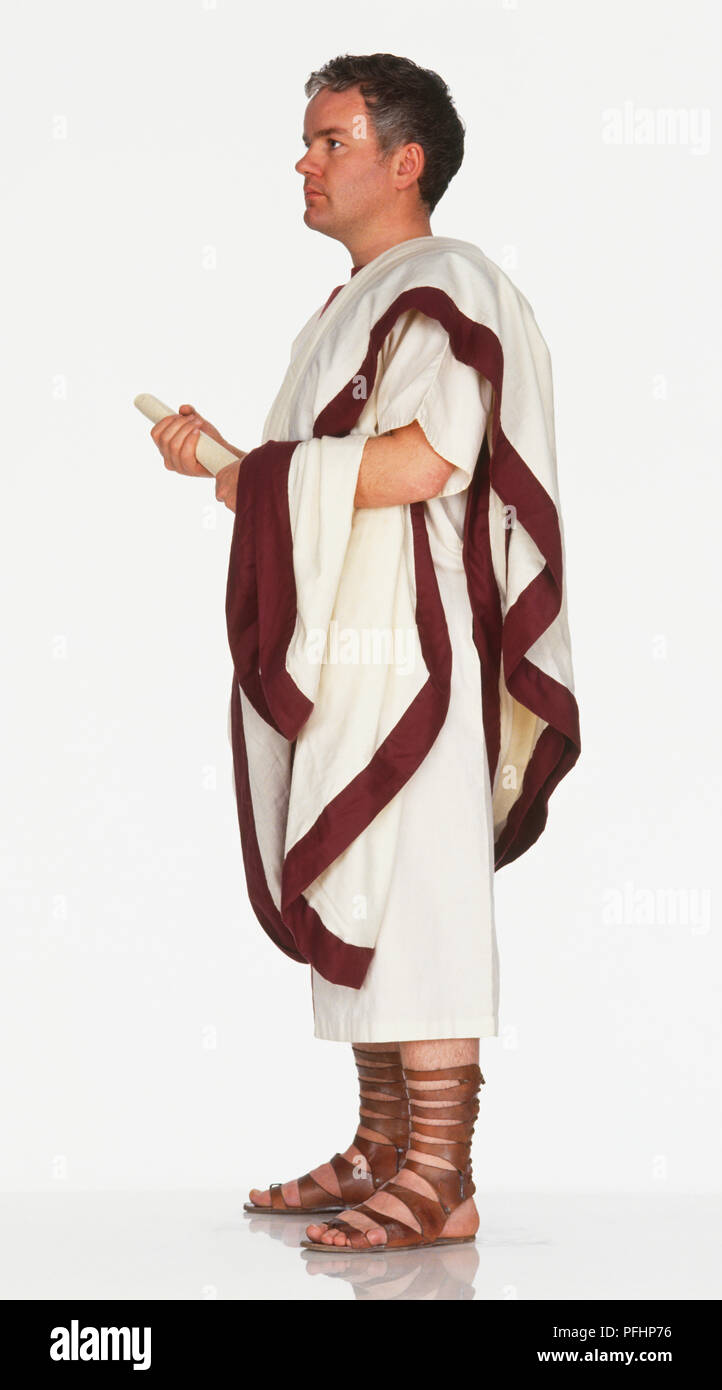 Man in Roman toga holding roll of parchment, side view Stock Photo