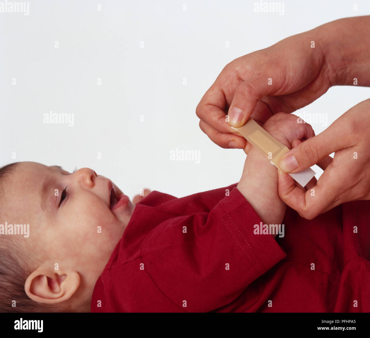 Putting plaster on hand of baby Stock Photo Alamy