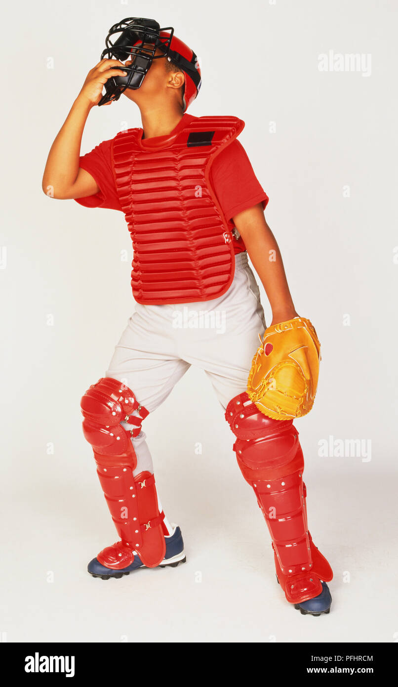 Boy wearing catcher equipment, face mask, chest protector and leg guard