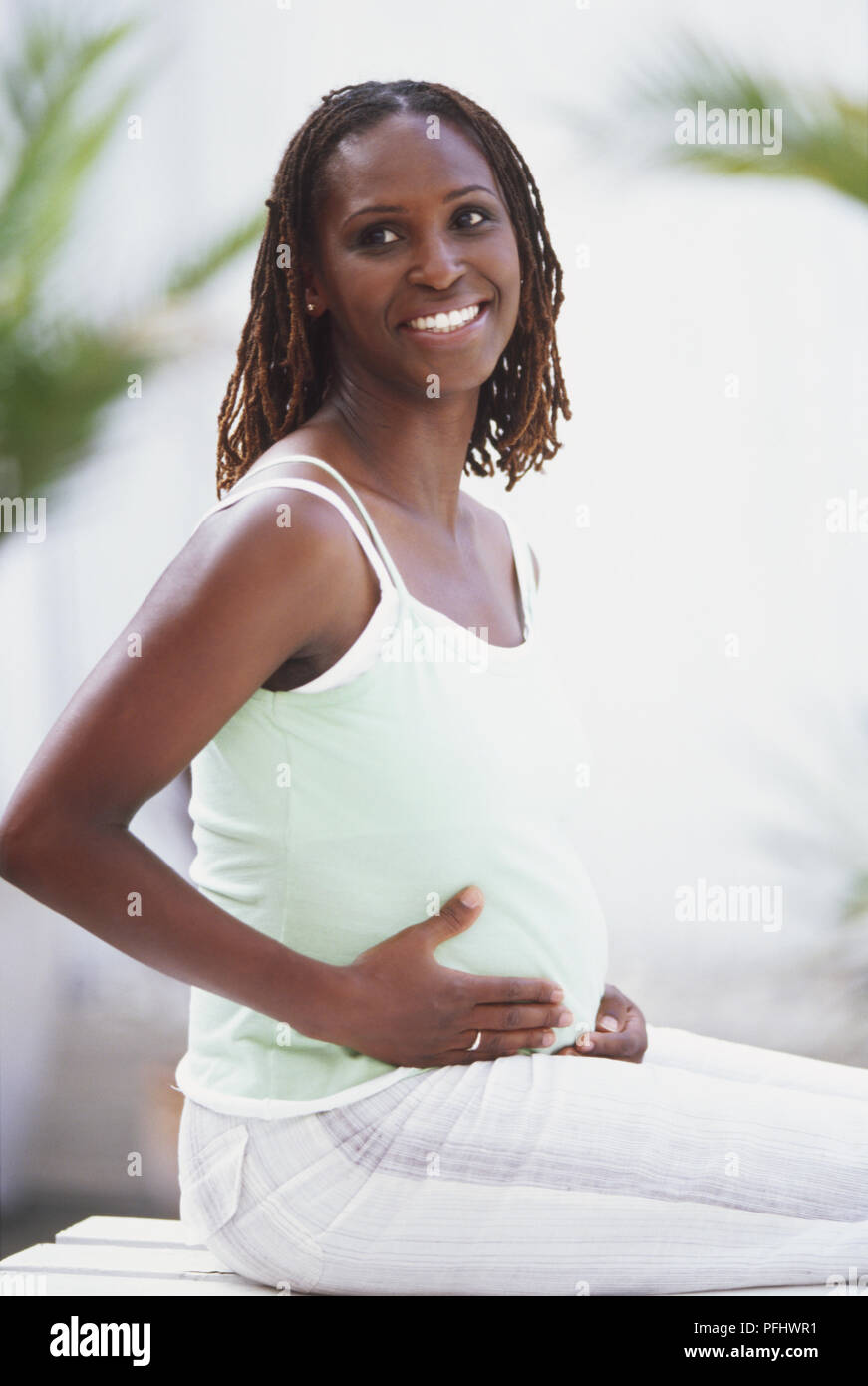 Premium Photo  Young african pregnant woman touching her belly outdoor at  city park focus on face