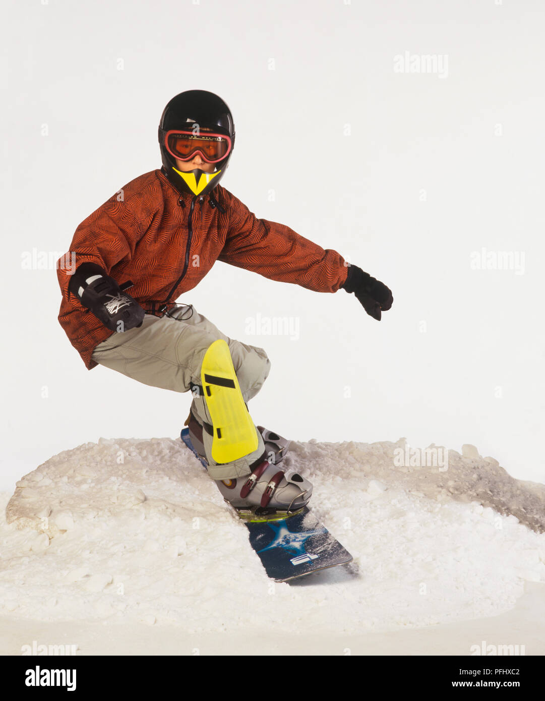 Chico en casco, gafas y rodilleras snowboard en nieve, vista delantera  Fotografía de stock - Alamy