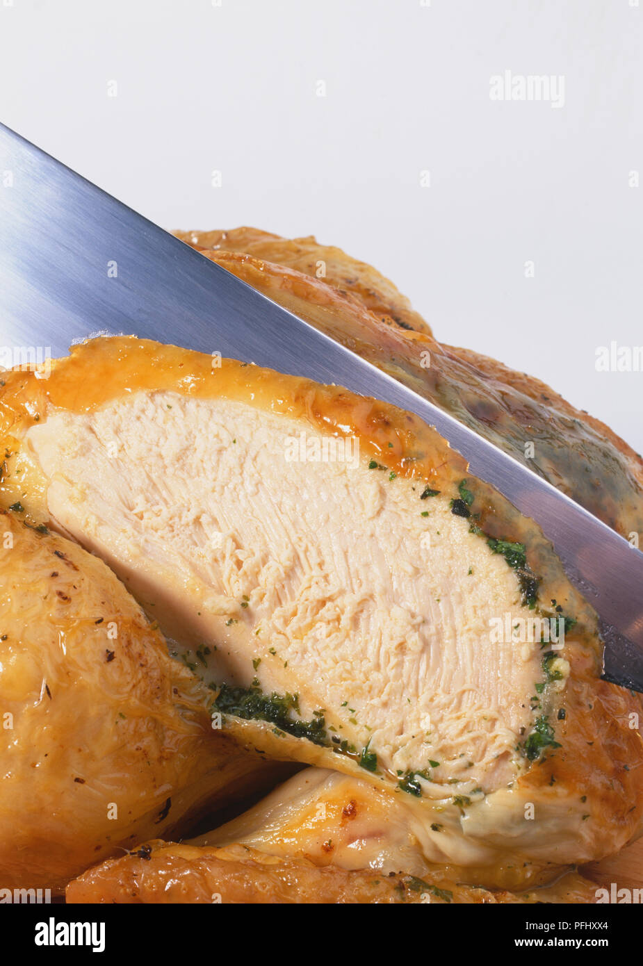 Knife carving a whole roasted chicken, close up Stock Photo Alamy