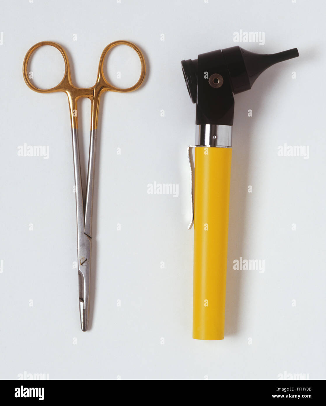 Otoscope with yellow handle and long thin scissors, close up. Stock Photo