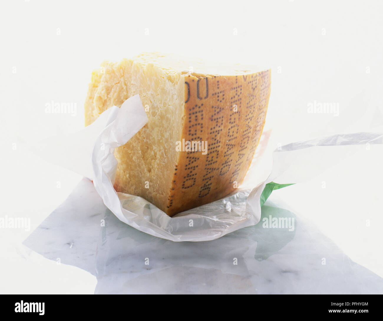 Block of parmesan cheese in greaseproof paper, close up Stock Photo - Alamy