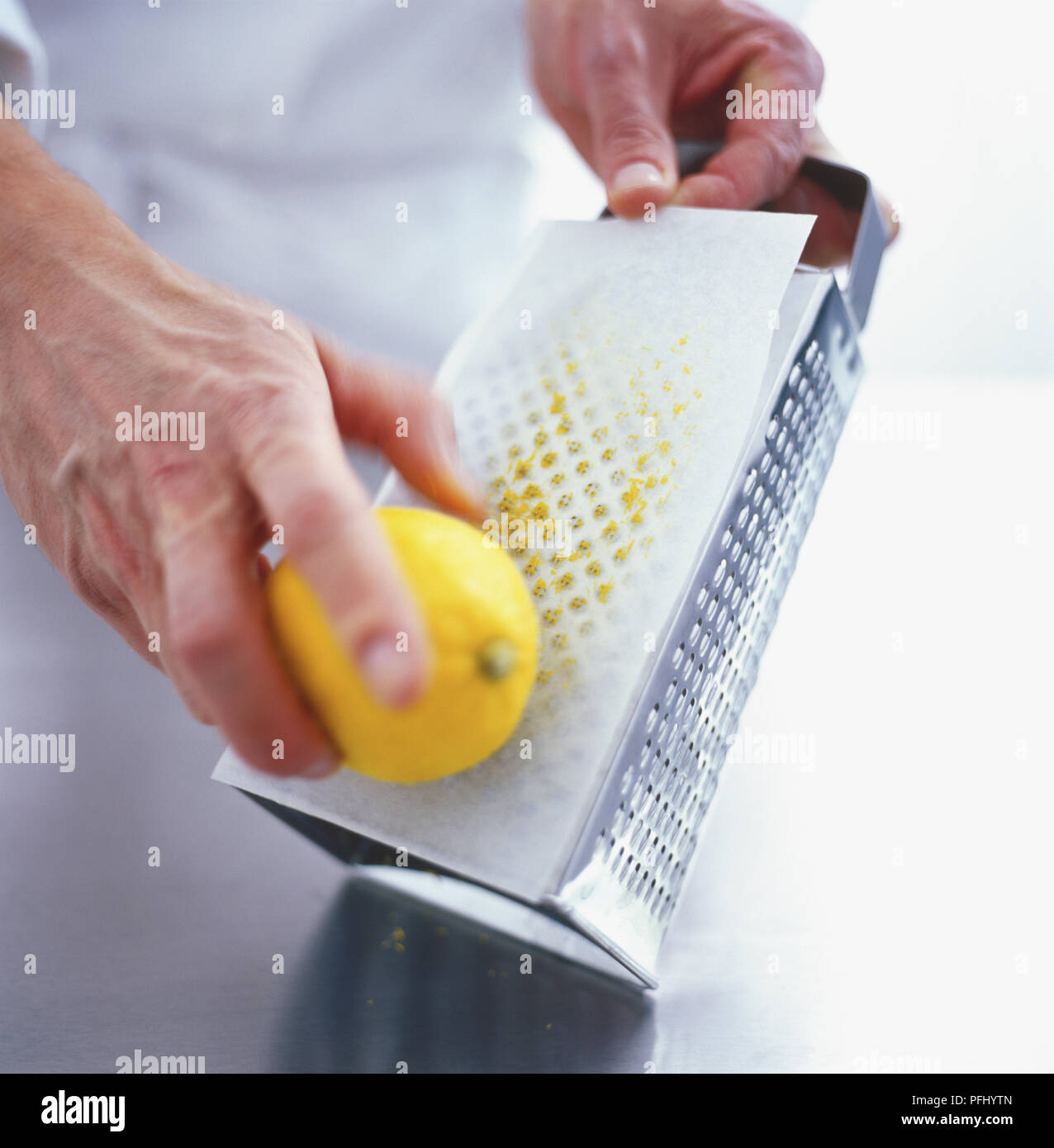 Using a metal grater to grate lemon zest Stock Photo Alamy