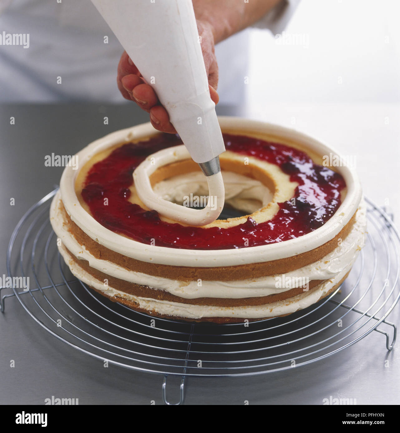 Using a piping bag to decorate layers of Frankfurter Kranz cake with