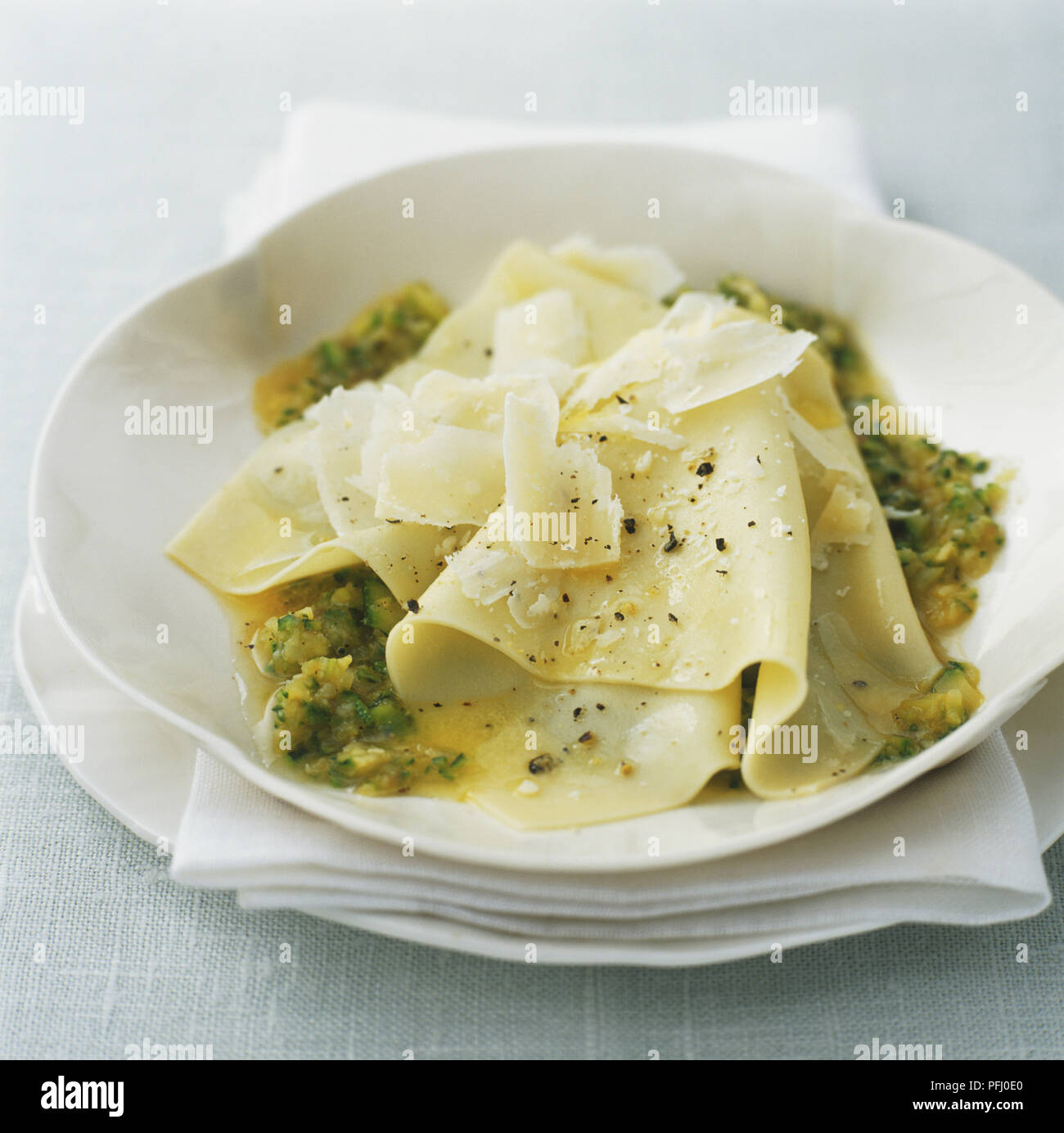 Fazzoletti pasta topped with cheese shavings and green sauce Stock Photo -  Alamy