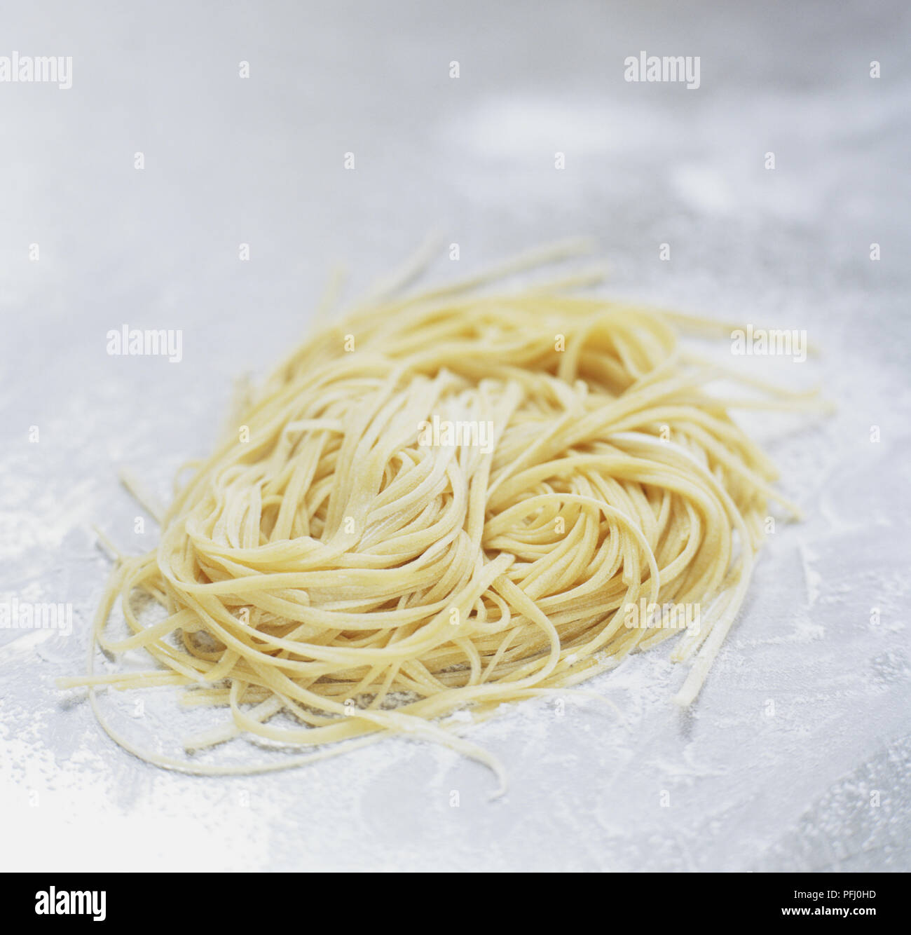 Uncooked eggs noodles on flourdusted surface Stock Photo Alamy