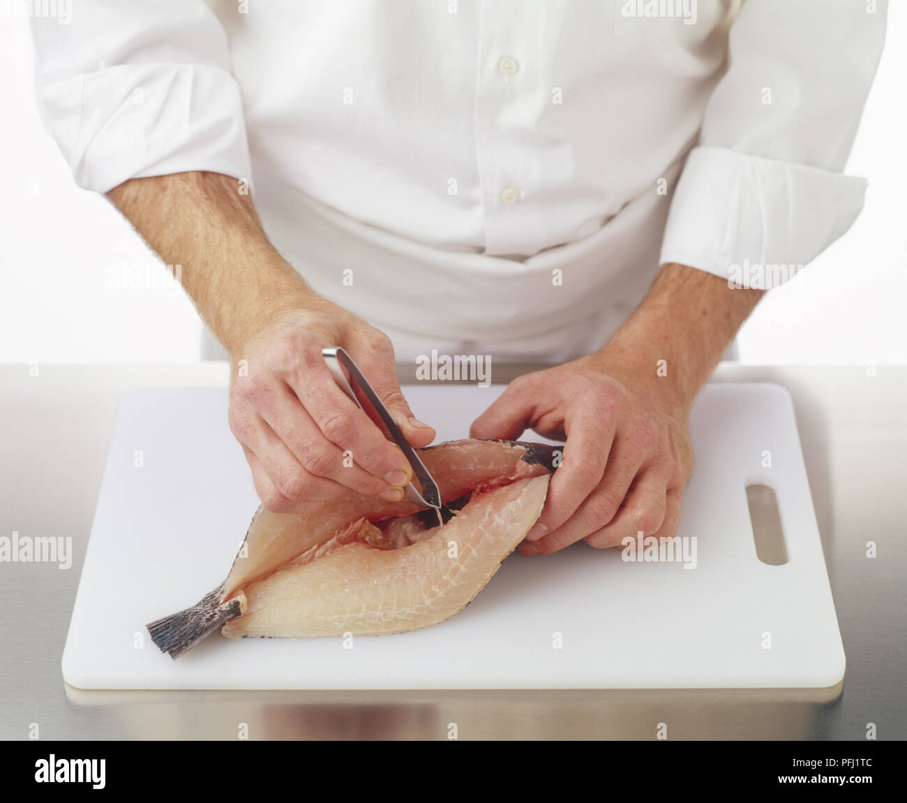 Using tweezers to pull out pin bones from a black sea bass Stock Photo Alamy
