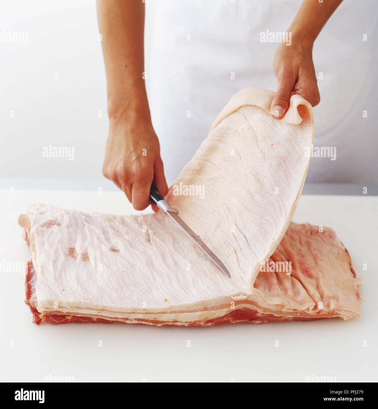 Stripping layer of fat off flat slice of raw meat Stock Photo Alamy