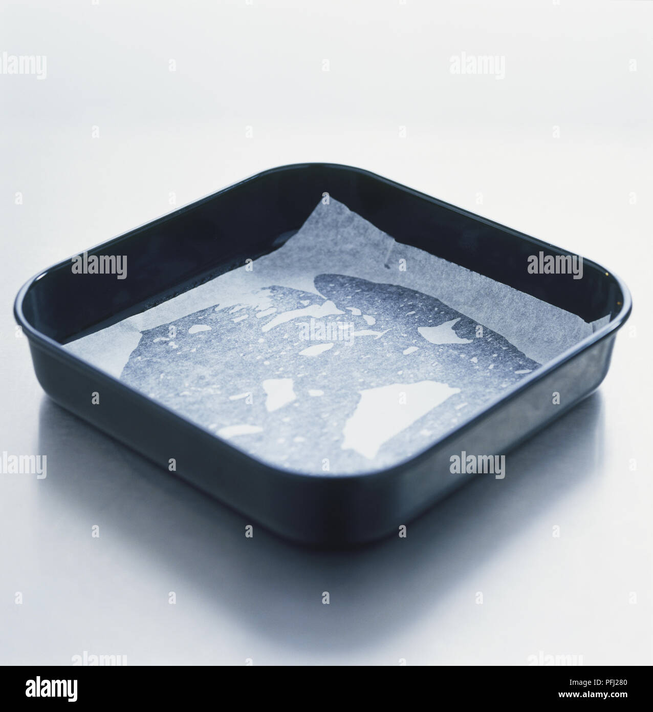 Baking tray lined with greasestained baking paper Stock Photo Alamy