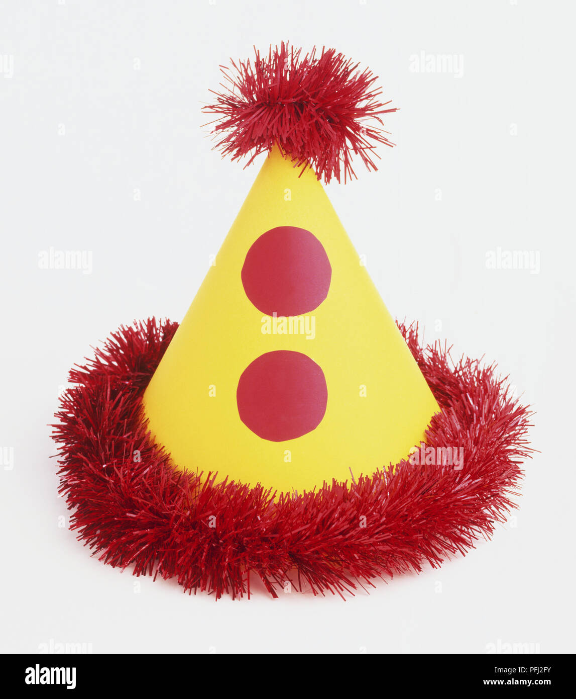Yellow conical hat lined with red tinsel Stock Photo Alamy