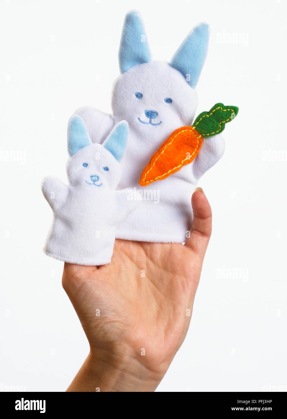 Two rabbit finger puppets on a woman's hand Stock Photo