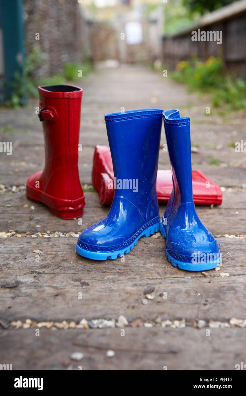 Two pairs of children's red and blue Wellington boots in alley Stock ...
