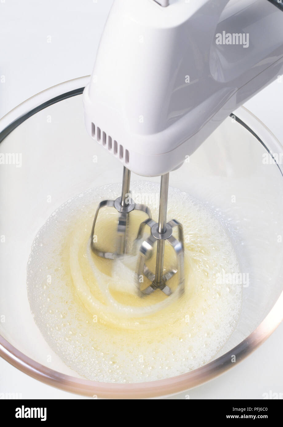 Electric mixer whisking egg whites in a glass bowl Stock Photo - Alamy
