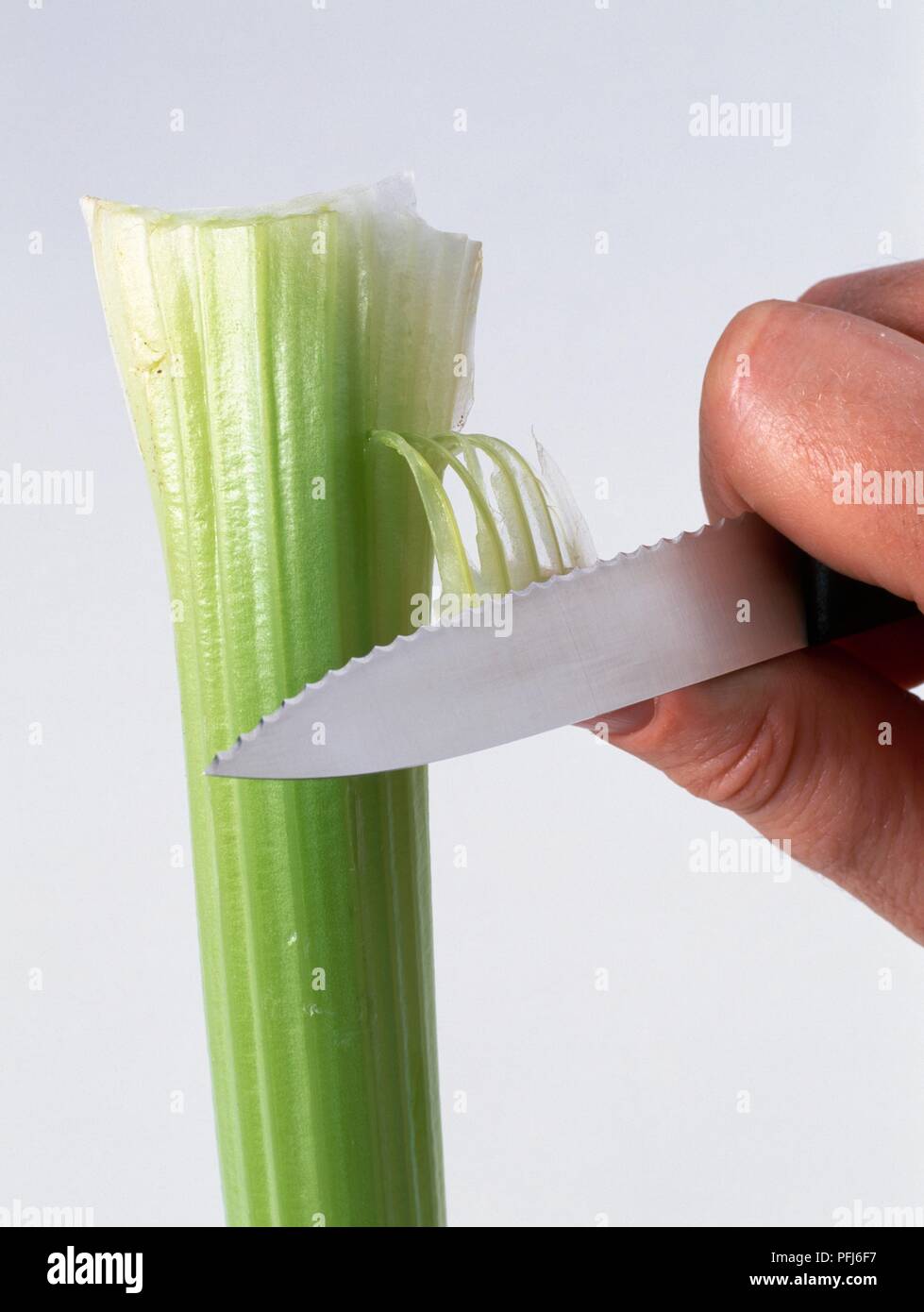 Using knife to peel celery stem Stock Photo Alamy