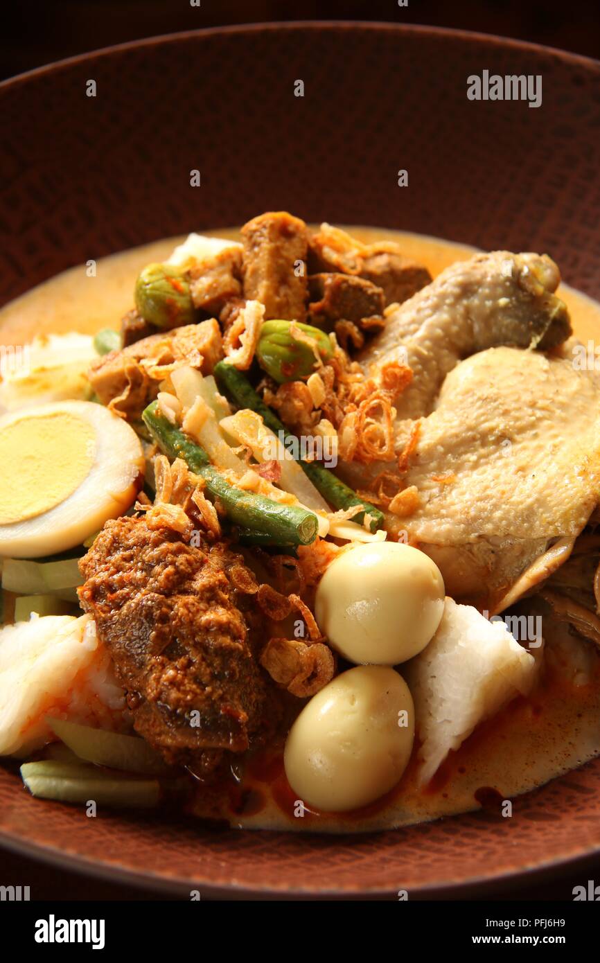 Ketupat Lebaran, the traditional celebratory dish of rice cake with several side dishes; popular during Eid celebrations. Stock Photo
