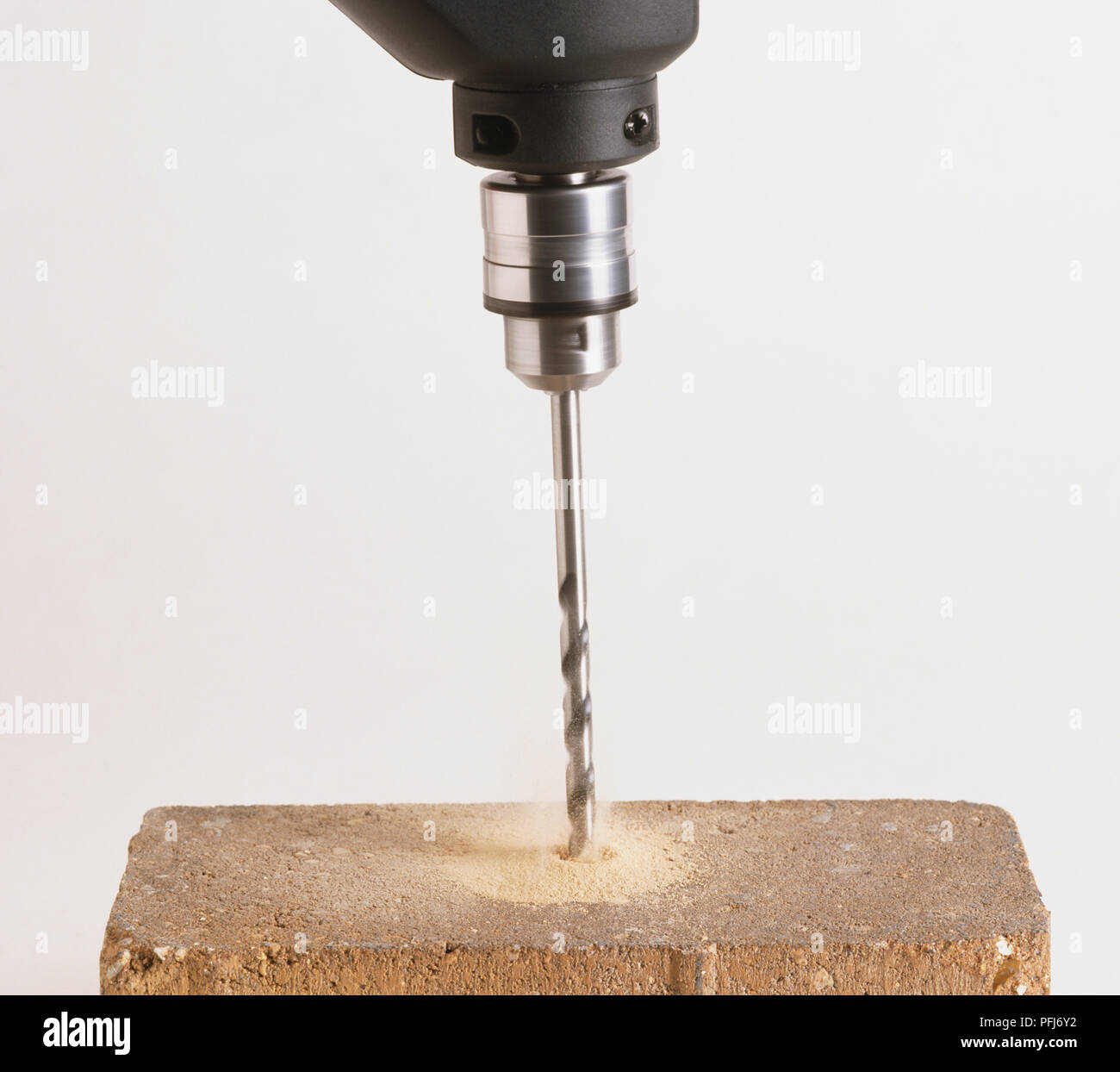 Electric drill drilling into red brick Stock Photo - Alamy