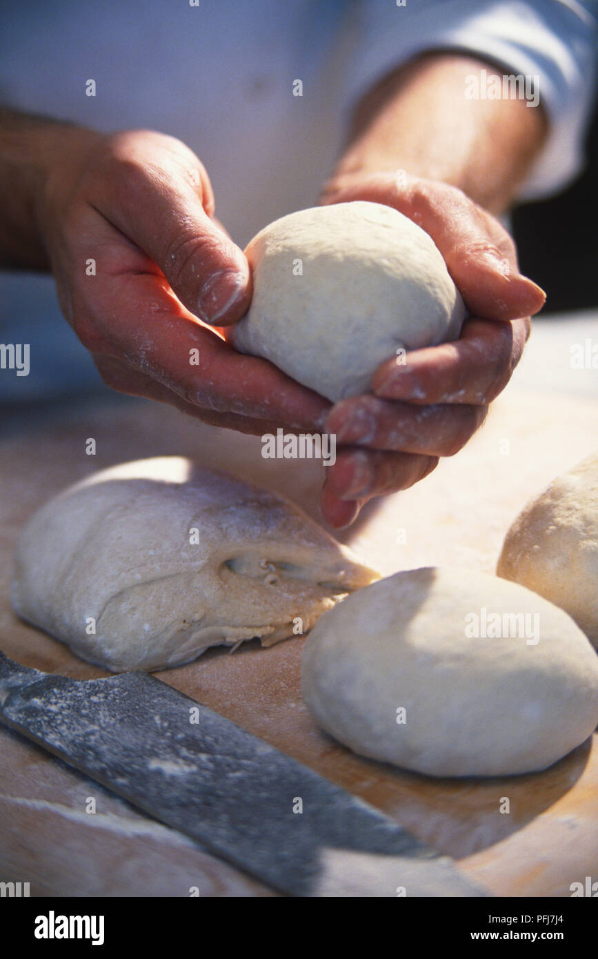 Hand shaping dough into ball, fresh dough, dough balls and pizza peel