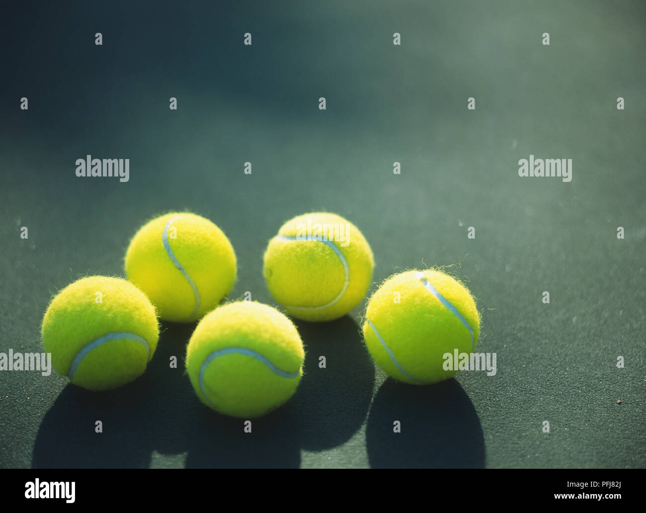 Five yellow tennis balls on green background Stock Photo Alamy
