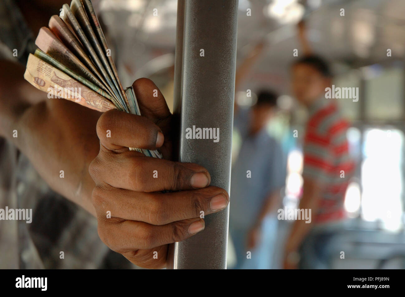India, man holding banknotes on bus Stock Photo