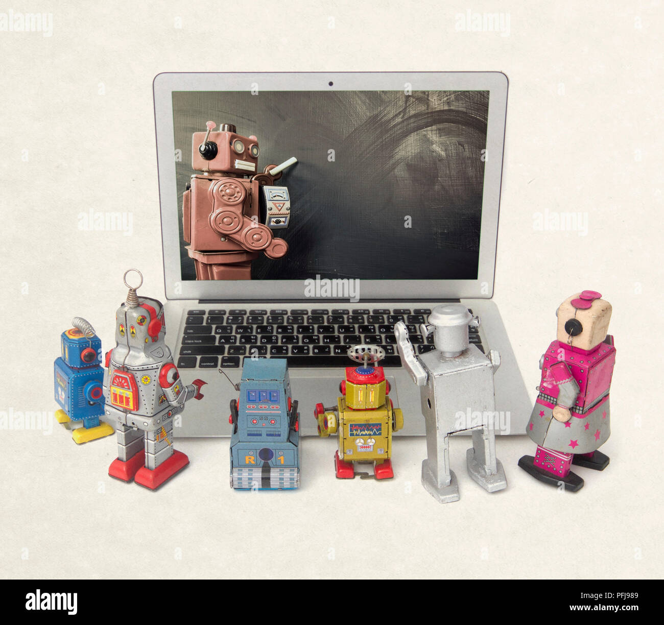 Robot Using Old Computer Machine learning concept with retro robots at a laptop computer ...