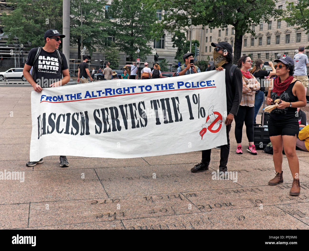 'Fascism Serves the 1%' sign is unfurled in Freedom Park in Washington D.C. during the 'Unite the Right 2' counterprotest prior to their march Stock Photo