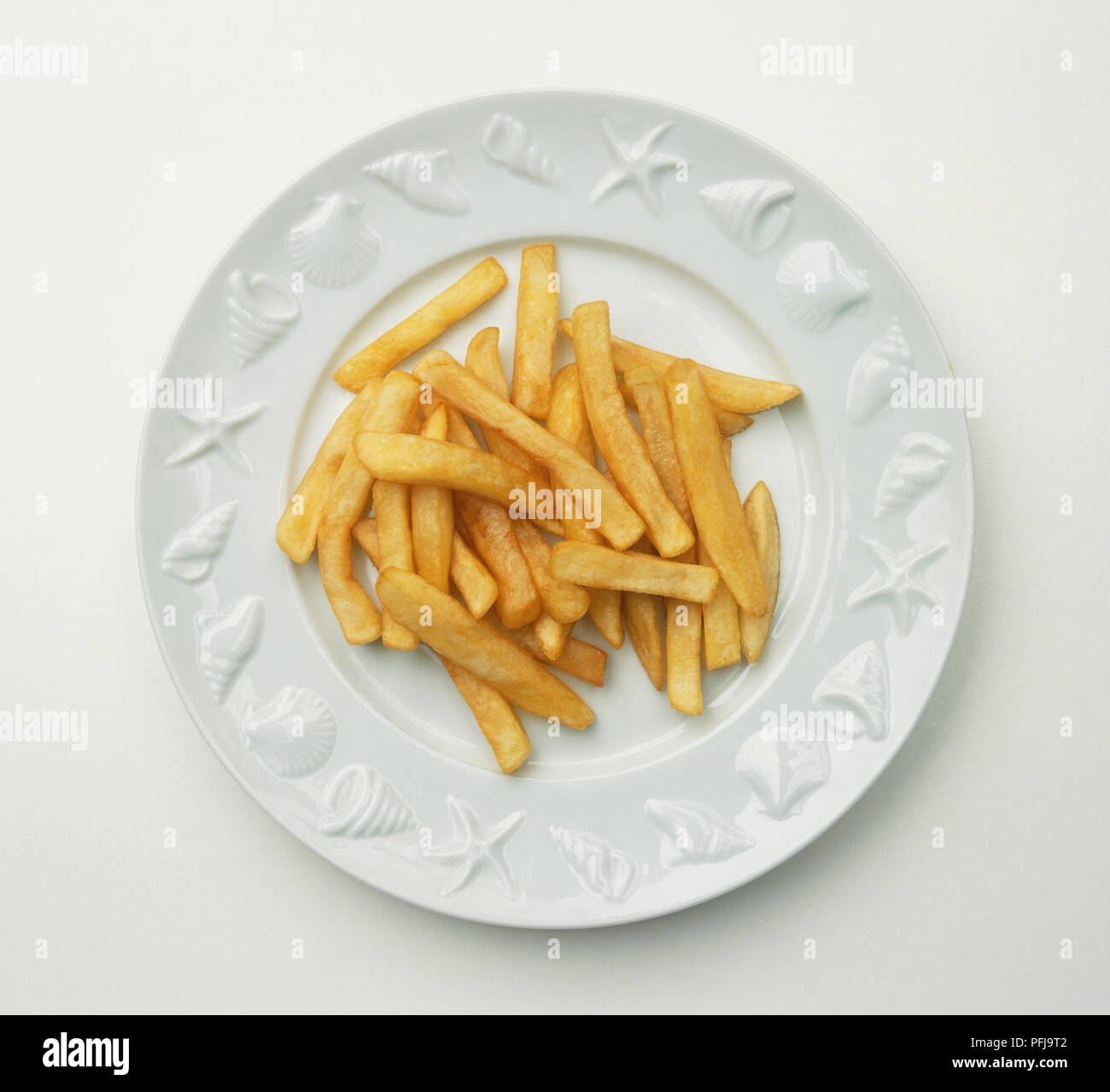 Chips on a white plate, rim showing sea life design, view from above Stock Photo