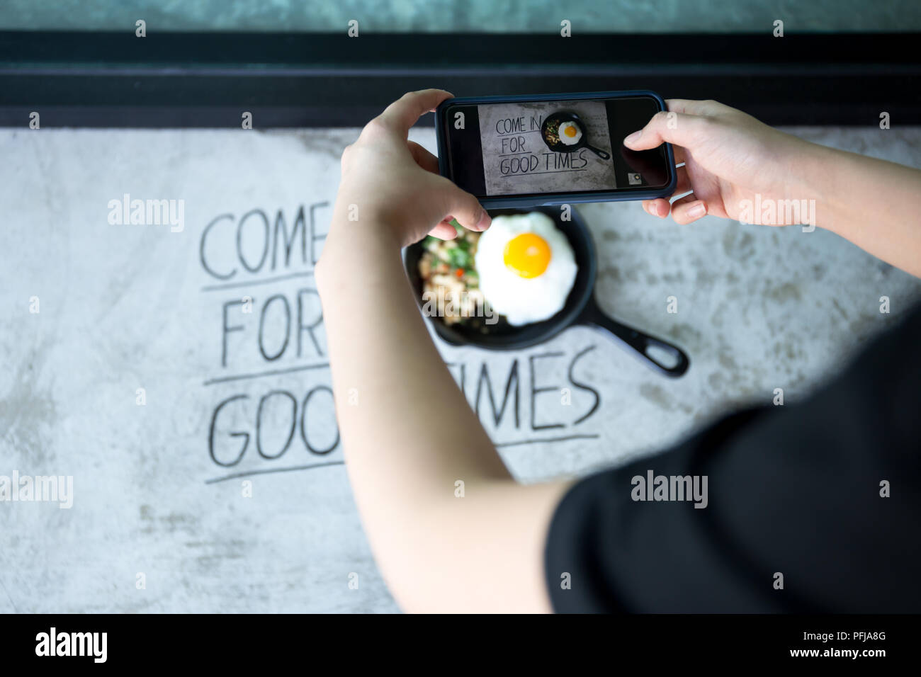 Selected focus woman taking picture with cell phone on stir fried ...