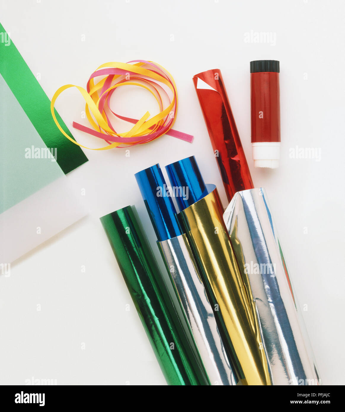 Rolls of green, red and blue paper, ribbons and glue stick Stock Photo