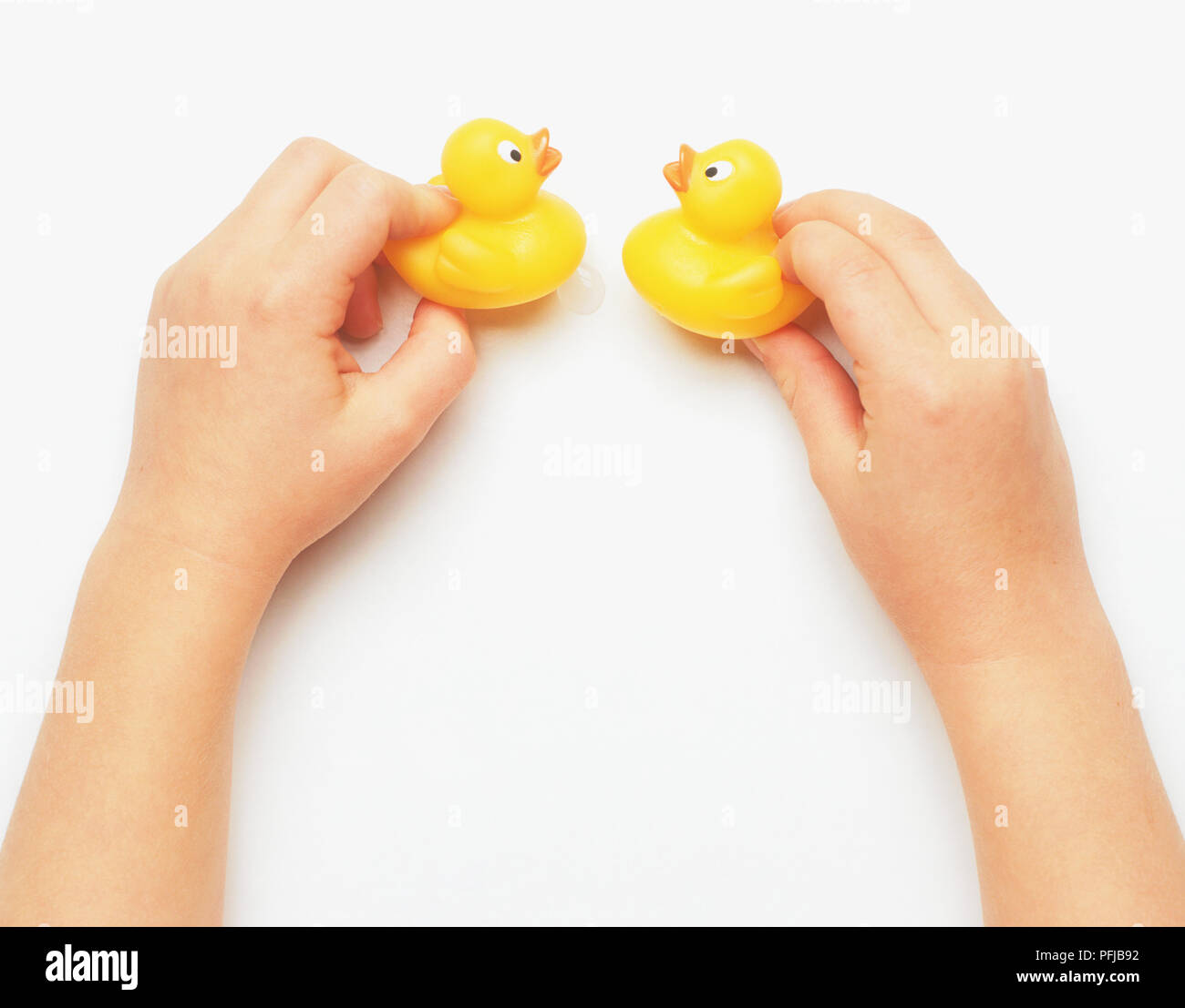 Pair of hands holding up two yellow rubber ducks Stock Photo