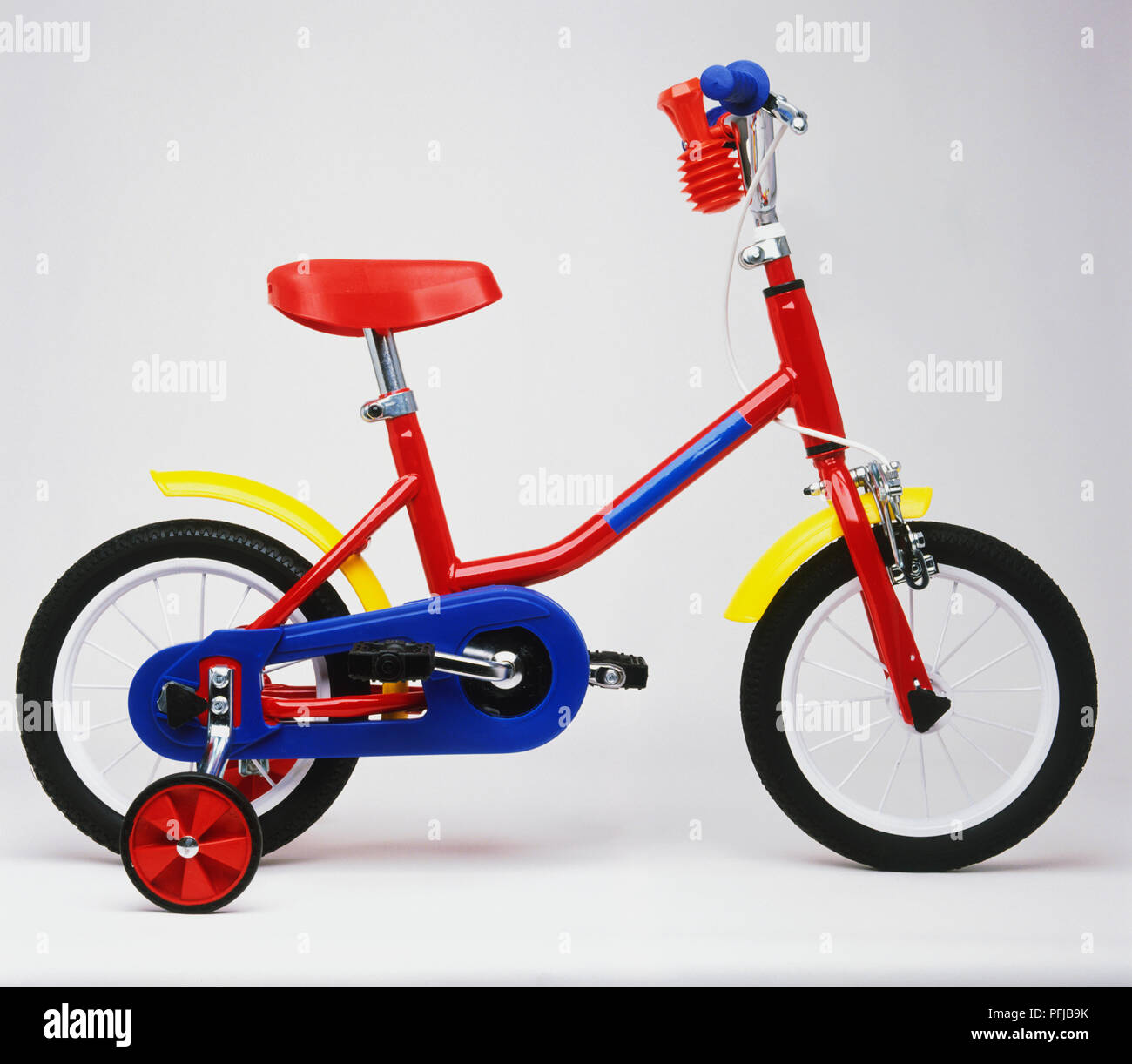 Child's colourful bicycle with stabilisers, side view Stock Photo