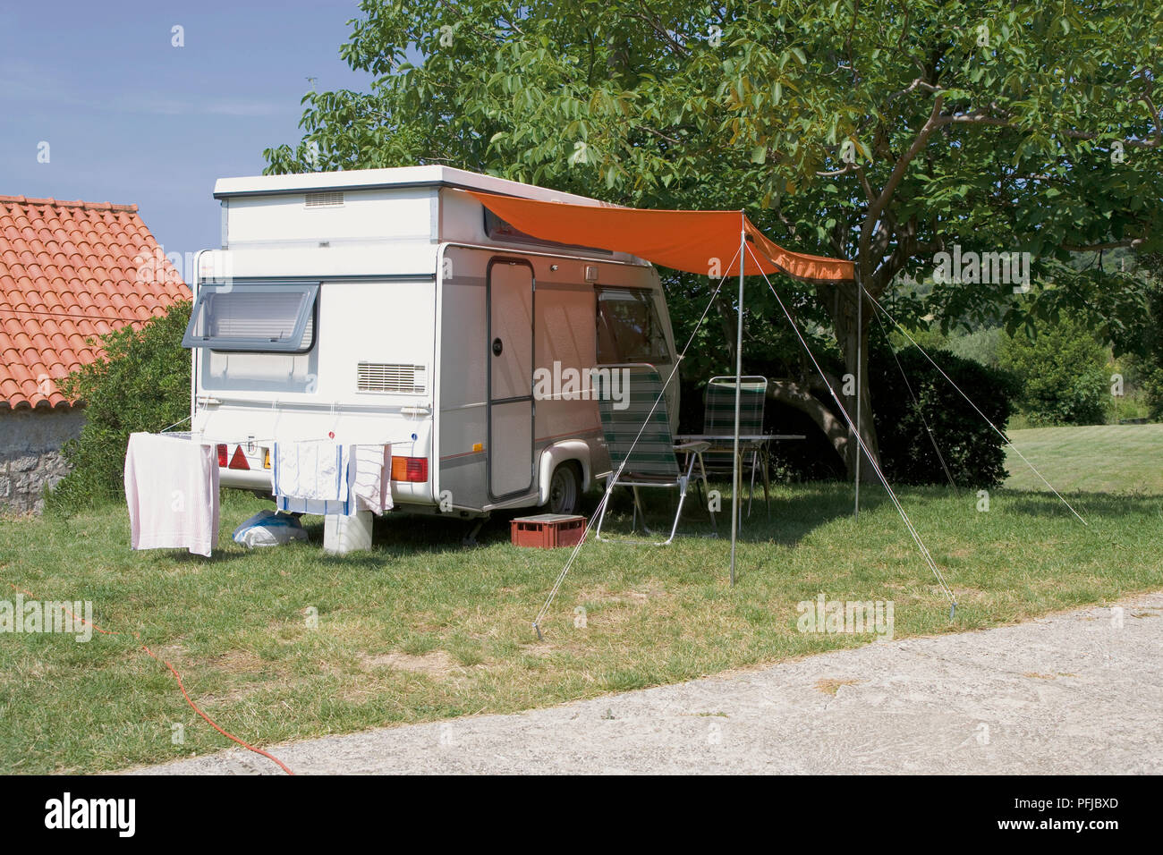 Croatia, motor caravan with awning parked under tree Stock Photo