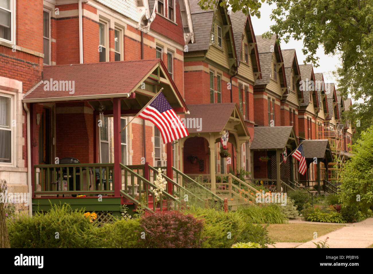 USA, Illinois, terrace of red brick houses with Stars And Stripes flags