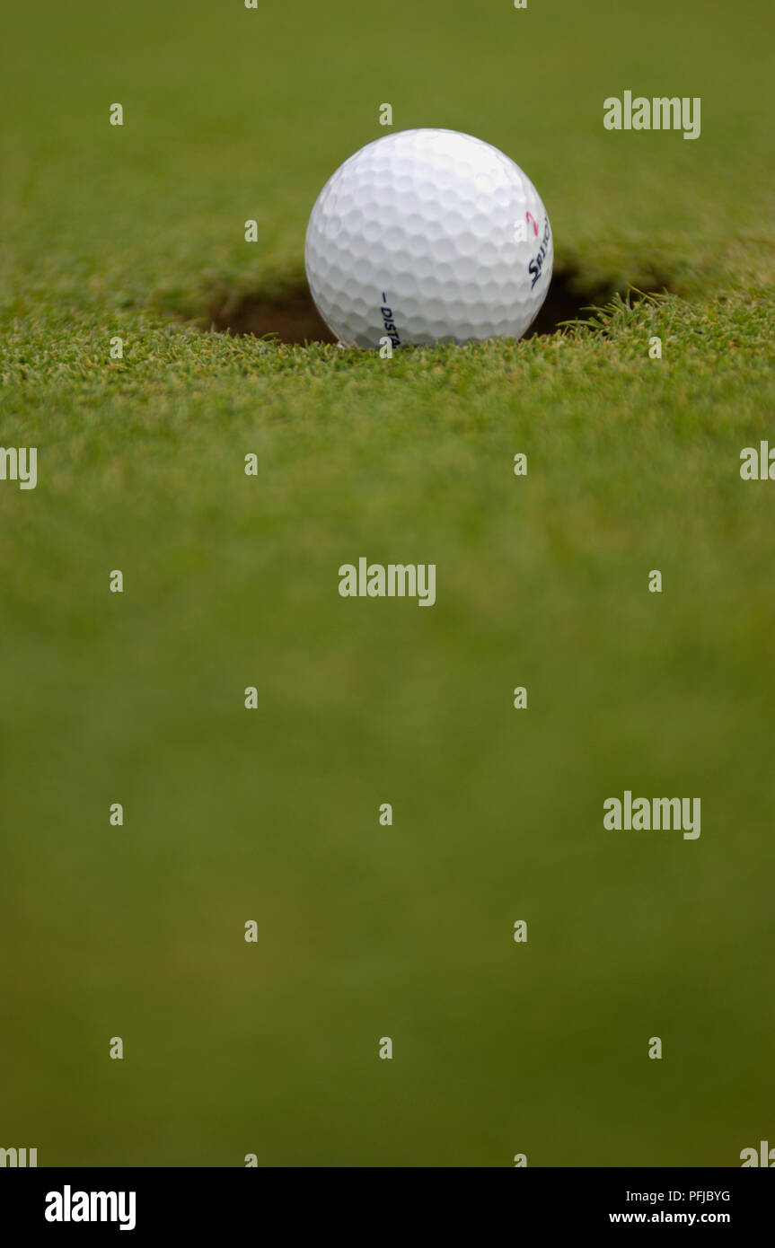 Golf ball in hole, differential focus Stock Photo Alamy