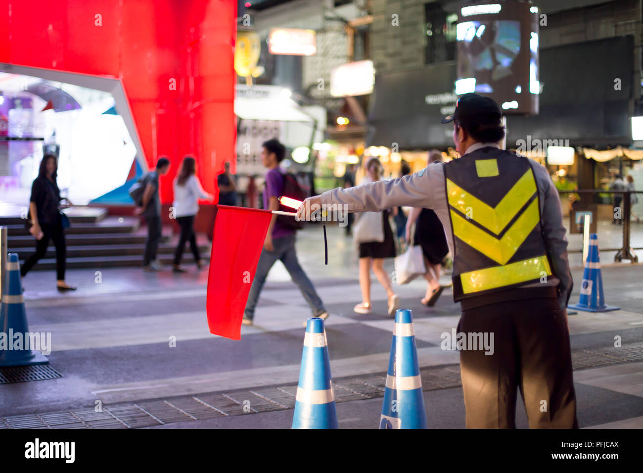 Traffic controlling with red flag stop the car for people crossing the