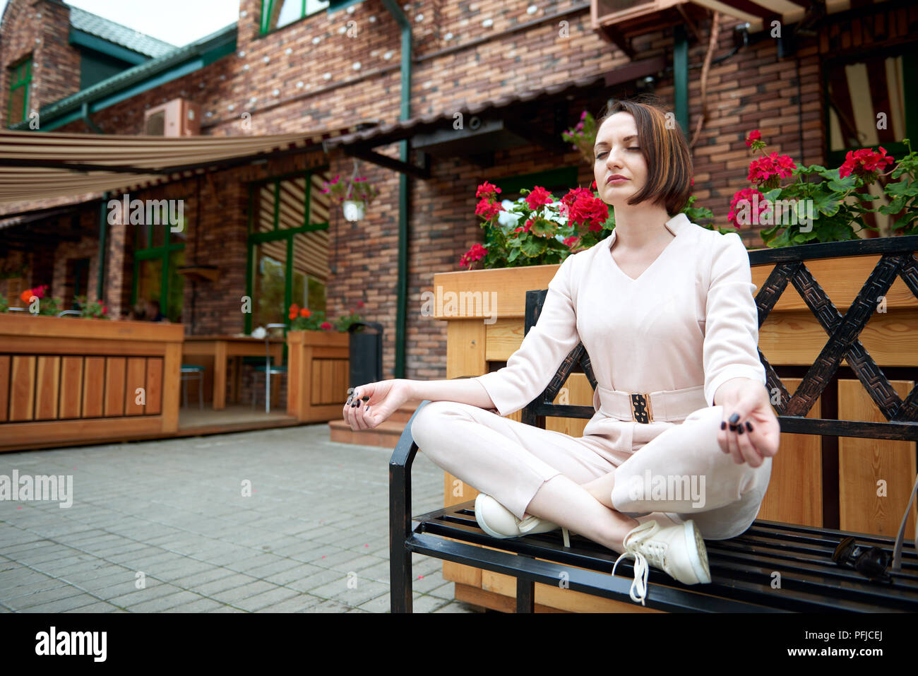 young girl meditating in the street, sitting on a bench Stock Photo - Alamy
