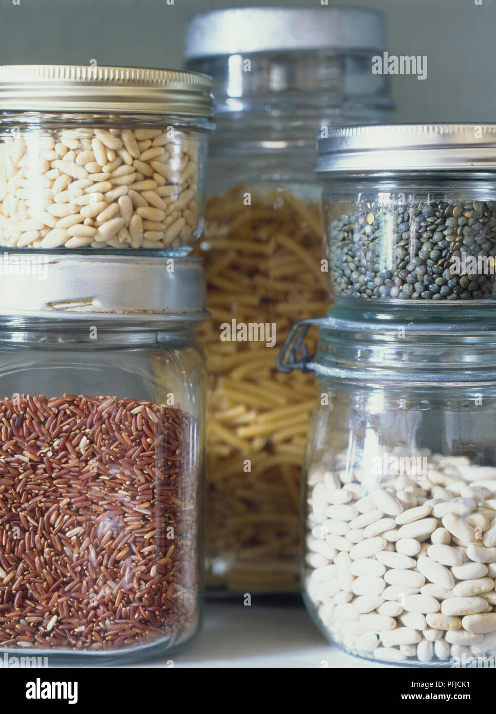 Various dried food in glass jars, including pasta, pluses and red rice, close-up Stock Photo