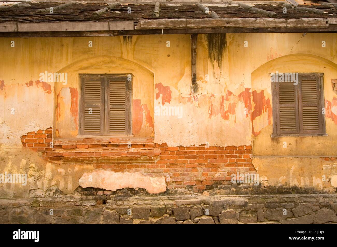 Vietnam, Hoi An, flaking plasterwork and exposed brick on exterior of building Stock Photo