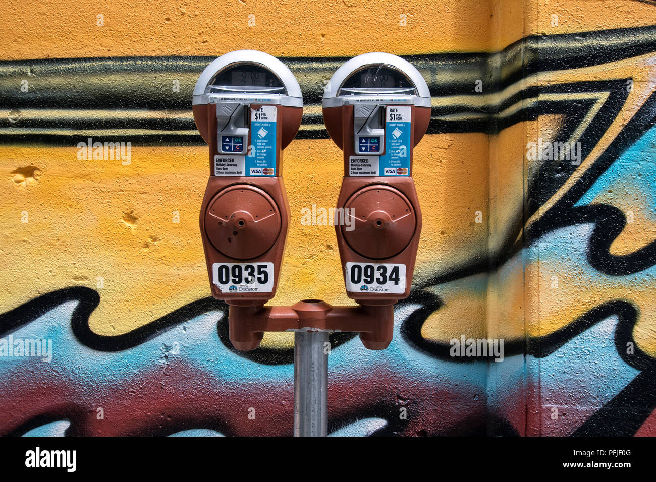 Parking meter in front of a colorful wall painting in Evanston, Illinois, USA. Stock Photo