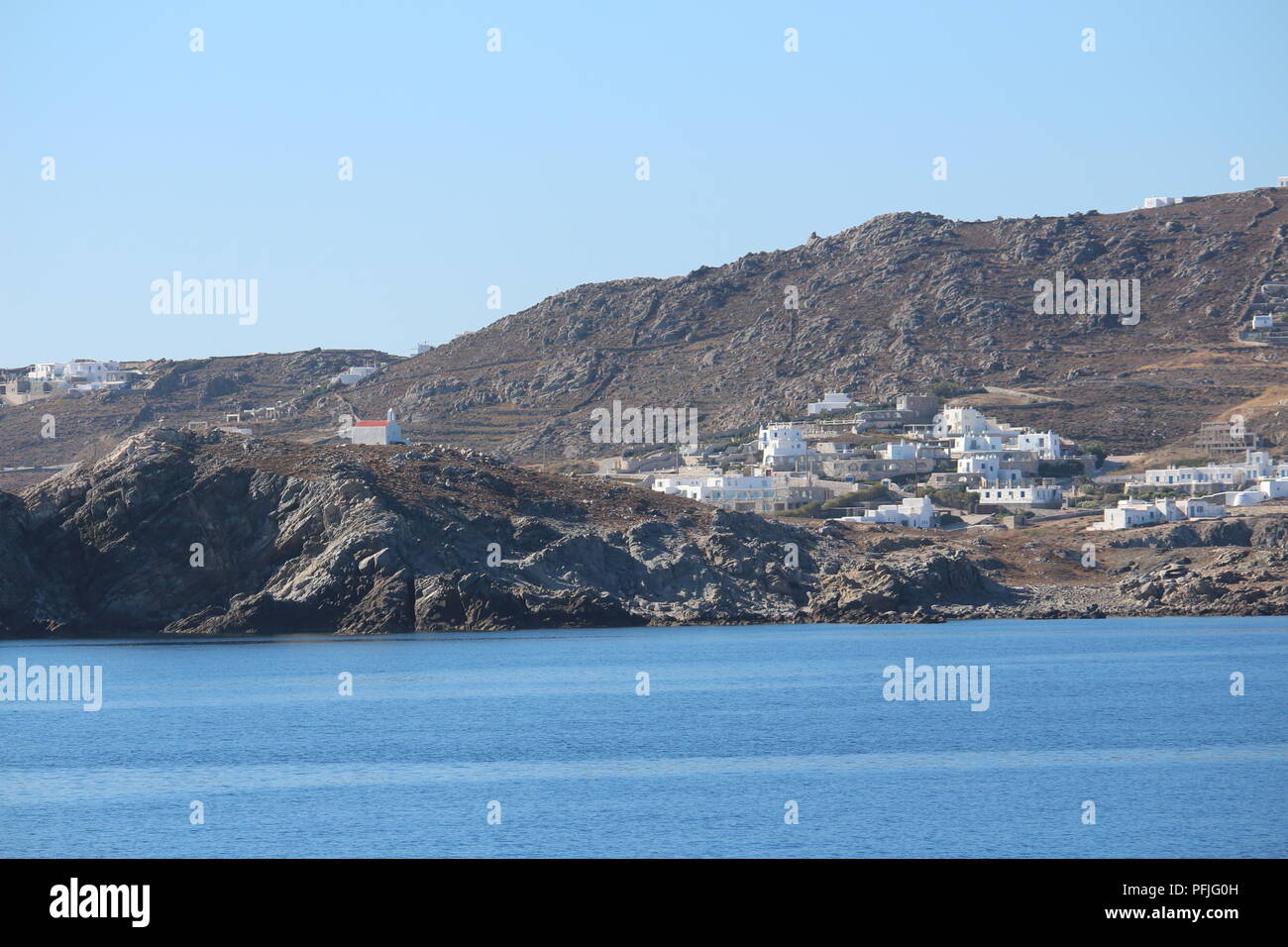 View of the island of Mykonos from a distance showing villages on the hills Stock Photo