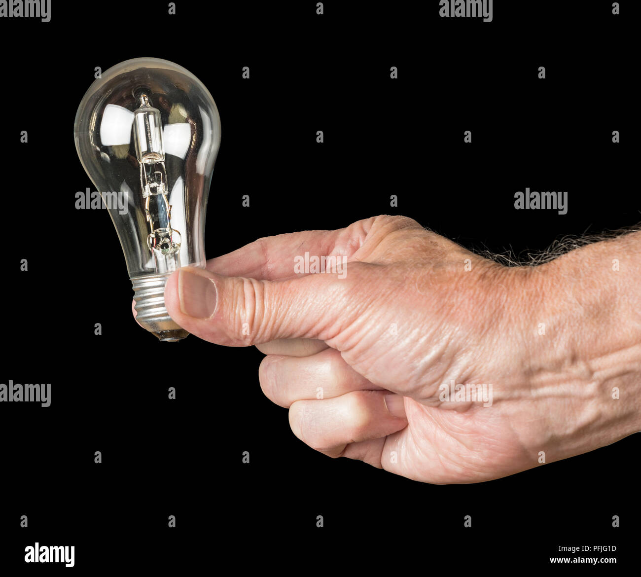 Mans hand holding a halogen lightbulb soon to be banned in the EU Stock Photo