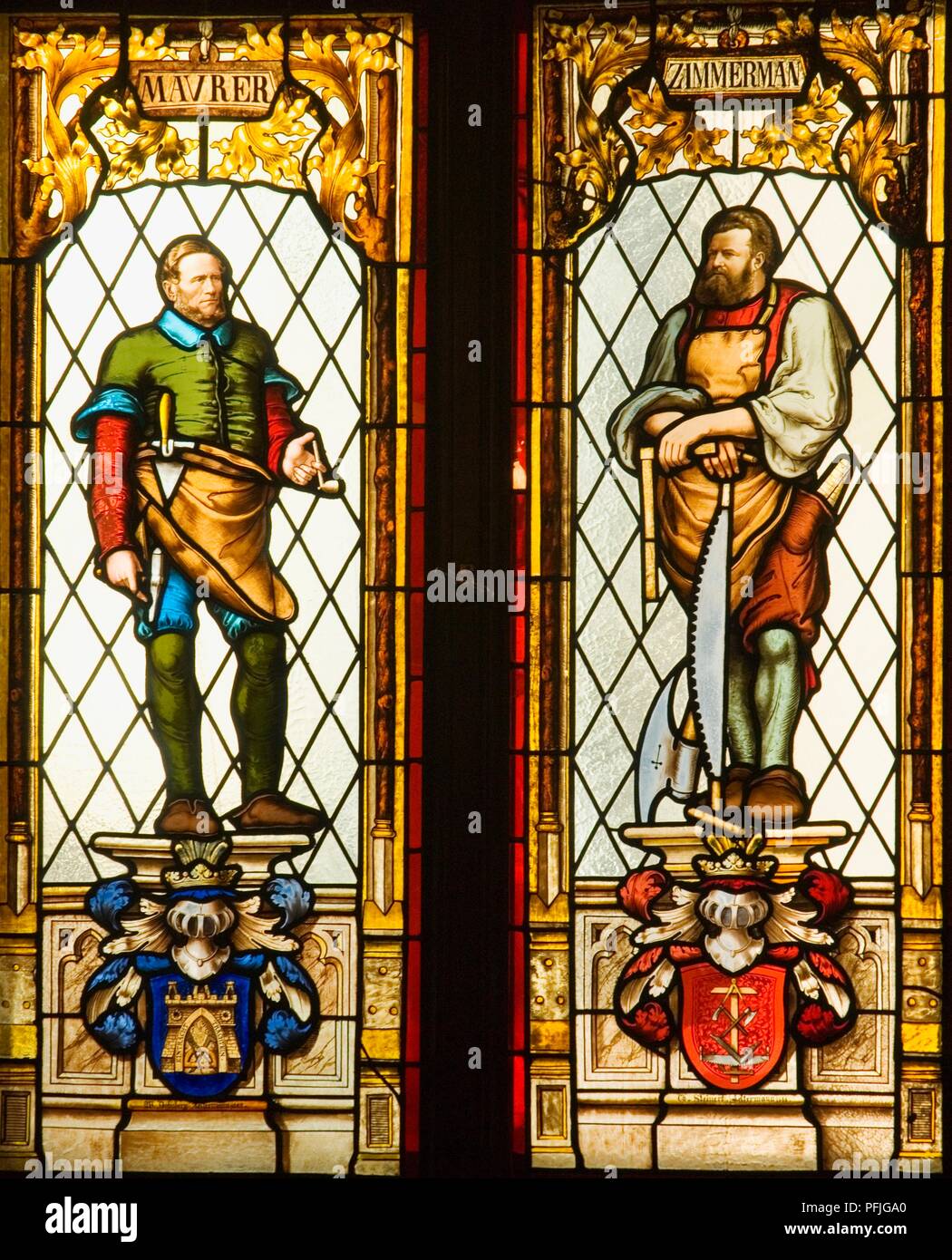 Latvia, Riga, Small Guild Hall, detail of craftsmen on stained glass windows, text in German 'Maurer' (mason) and 'Zimmerman' (carpenter) Stock Photo