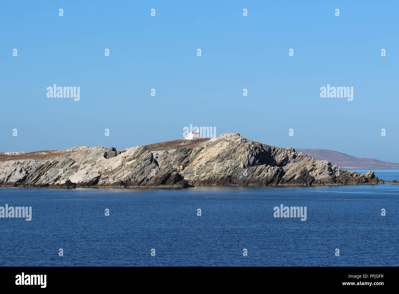 Little white church on rocky cliffs on the island of Mykonos Greece Stock Photo